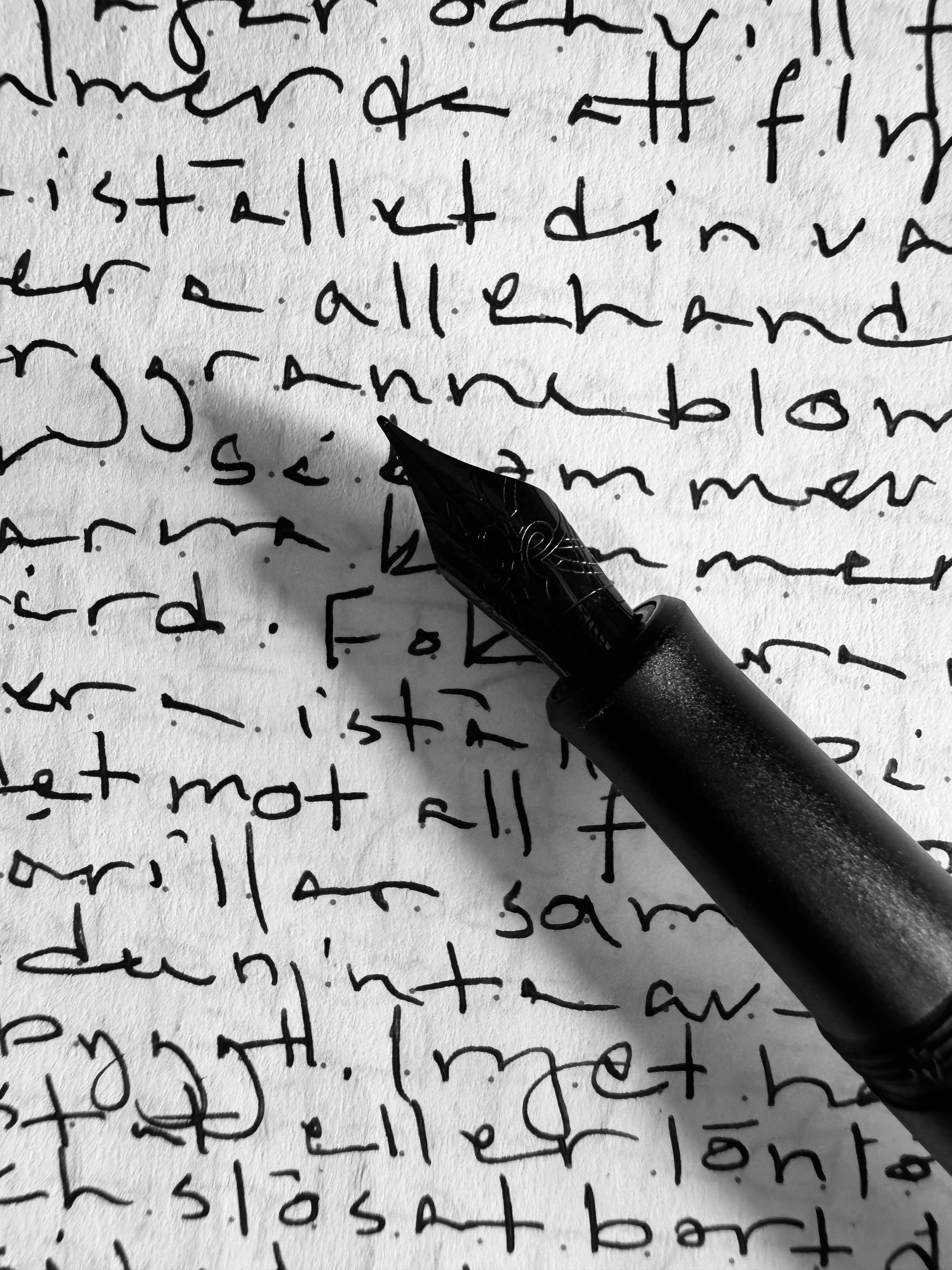 A fountain pen rests on a page filled with handwritten text.